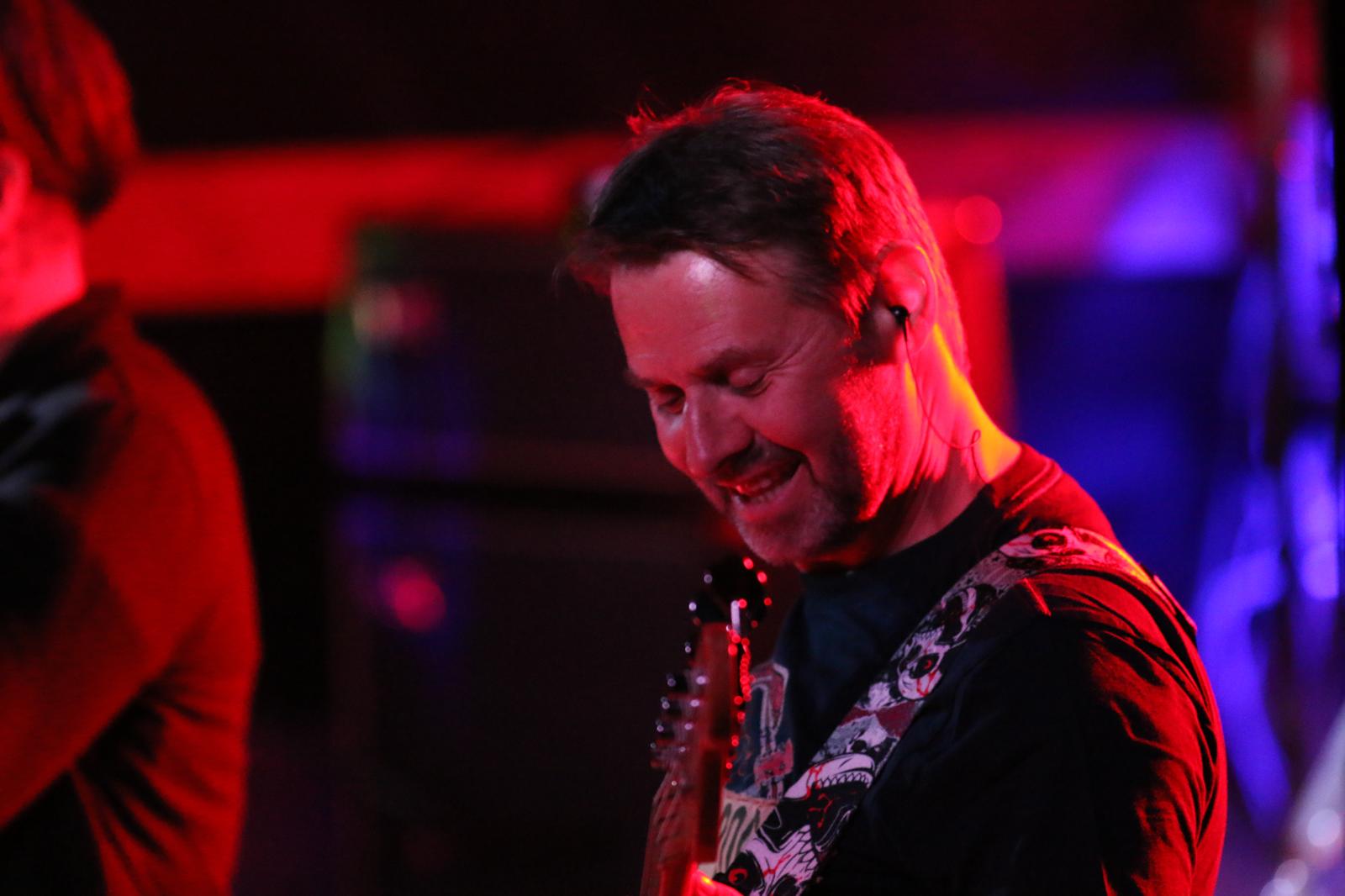 Gitarrist von Yellow Snow beim Spielen im roten Bühnenlicht